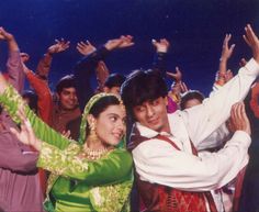 a man and woman standing next to each other with their arms in the air