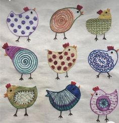 a bunch of different colored birds on a white cloth