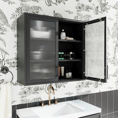 a bathroom sink and cabinet in front of a wallpapered wall