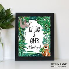 a card and gift box sitting on top of a table next to a plant