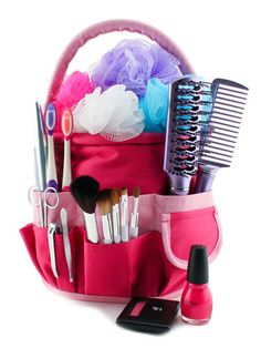 a pink purse filled with lots of different types of makeup and hair brushes in it