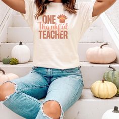 Thankful Thanksgiving Teacher T-shirt. Great for Gifts and Parties. Perfect for Thanksgiving dinner, teachers and homeschool teachers. This classic unisex jersey short sleeve tee fits like a well-loved favorite. Soft cotton and quality print make users fall in love with it over and over again. These t-shirts have-ribbed knit collars to bolster shaping. The shoulders have taping for better fit over time. Dual side seams hold the garment's shape for longer. \n.: 100% Airlume combed and ringspun co Fall Teacher Tshirts, Teacher Thanksgiving Shirts, Casual Short Sleeve Shirt For Teaching, White Pre-shrunk T-shirt, Relaxed Fit T-shirt For School In Fall, White Relaxed Fit T-shirt For School, Relaxed Fit School Spirit T-shirt For Fall, White Relaxed Fit Top For Teaching, White Graphic Tee For Teaching