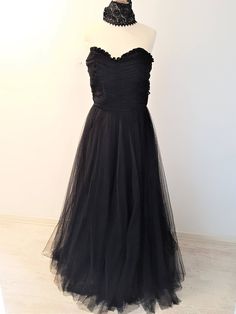 A stunning full length strapless Black Dress with matching Black Lace Choker. The dress has an elegant Sweetheart neckline with ruffled trimming. The bodice is elegantly ruched. The skirt of the dress is A-line and suits any figure. It is a full, but not puffy tulle skirt. The lace choker adds that extra UMPH to the dress. Its quite a thick choker, which gives it a unique appearance. Quite a statement maker! Size:  EU: 36/38 UK: 8/10 US: 4/6 Black Ruched Evening Dress With Sweetheart Neckline, Black Evening Dress With Ruched Sweetheart Neckline, Black Evening Dress With Sweetheart Neckline And Ruched Detail, Black Evening Dress With Ruched Bodice For Prom, Strapless Ruffled Evening Gown, Evening Strapless Ball Gown With Ruffles, Black Prom Gown With Ruched Bodice, Strapless Evening Gown With Ruffles, Formal Strapless Floor-length Dress With Ruffles