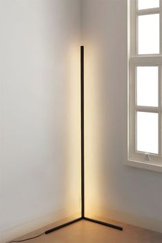 a lamp that is sitting on the floor next to a window