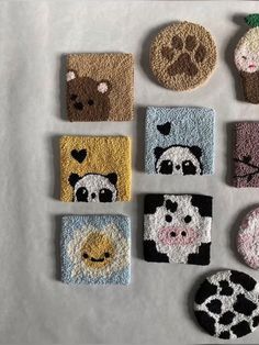 nine different animal coasters are arranged on a table top, including one with a bear, panda, giraffe, and other animals