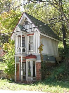 an old white house sitting in the middle of a forest