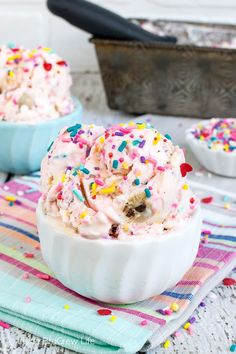 two bowls filled with ice cream and sprinkles on top of a table