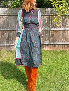 This vintage 70s homemade folk dress is truly a work of art, made with so many thoughtful, exquisite details. Somewhere between a Bill Tice and Young Edwardian, there are so many lovely design features, like the quilting on the front and back yoke. The contrast color fabric is such a thoughtful choice by someone who truly loved garment making. And can we talk about the asymmetrical cutout on the neckline with decorative beaded cord? It's obvious that had fun choosing these playful design elements! Impeccable dark purple tipping along every seam. The jacquarded fabric sleeves and inset side panels in turquoise, plum and soft citron are such a beautiful complement to the moody, dark floral print on the front and back. A gorgeous straight silhouette that looks great with or without the belt. Traditional Green Fall Dresses, Vintage Multicolor Midi Dress For Fall, Multicolor Vintage Midi Dress For Fall, Fitted Folk Style Multicolor Dress, Fitted Multicolor Folk Dress, Fitted Floral Patchwork Dress For Fall, Multicolor Silk Dress For Fall, Multicolor Silk Dresses For Fall, Retro Patchwork Dress For Fall