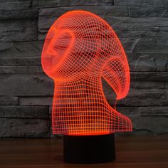 an illuminated sculpture of a person's head on a table