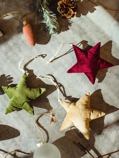 christmas ornaments are arranged on the floor next to pine cones