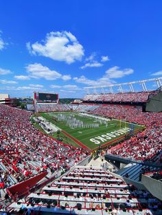 a football stadium filled with lots of red and white fans sitting on the bleachers