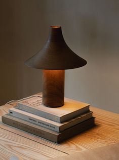 three books stacked on top of each other next to a lamp