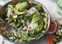 a salad with avocado, beans and spinach in a pan on a table