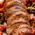 sliced pork roast on a white plate with roasted vegetables and text overlay that reads, how to cook the best loin roast recipe