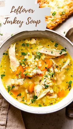 a white bowl filled with chicken and barley soup next to a slice of bread on a napkin