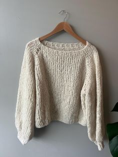 a white sweater hanging on a hanger