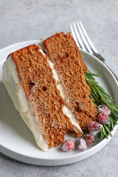 a slice of carrot cake on a plate with cranberries and powdered sugar