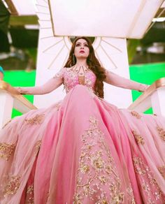 a woman in a pink dress is standing on stairs