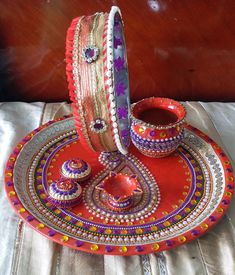 a red tray with two bracelets on top of it and a cup in the middle