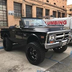 a black truck parked in front of a brick building