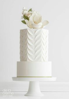 a white wedding cake with flowers on top