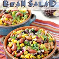 two bowls filled with bean salad on top of a table