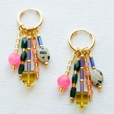 The Stevie Dangle Hoop Earrings are chock full of character! With an assortment of multi-colored natural stones, Czech glass, glass and gemstone beads, you are sure to have all the variety you could wish for. Forest green, pink hues, lavender and patterned beads come together to create all this cuteness. These hoop earrings feature small gold-filled hoops that have a wonderful assortment of baubles and beads that dangle below to give these earrings a fun touch of added movement. You are sure to Stone Bead Jewelry Ideas, Multicolor Hoop Earrings With Natural Stones, Multicolor Hoop Jewelry With Natural Stones, Multicolor Beaded Earrings With Natural Stones, Multicolor Natural Stones Hoop Jewelry, Multicolor Natural Stone Hoop Jewelry, Multicolor Beaded Drop Earrings With Natural Stones, Multicolor Natural Stones Beaded Drop Earrings, Multicolor Hoop Earrings With Natural Stones For Gift