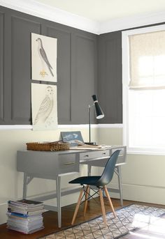 a home office with green walls and white trim on the walls, along with a gray desk