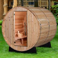 a wooden barrel sauna in the grass