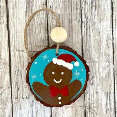 a wooden ornament with a christmas decoration on it's face and a red bow tie