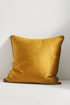 a gold pillow sitting on top of a white table