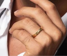 a close up of a person wearing a gold ring