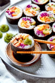 sushi with chopsticks and sauce on a plate