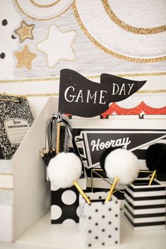 some black and white items are sitting on a shelf in front of a game day sign