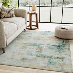 a living room area with a couch, coffee table and large window looking out onto the outdoors