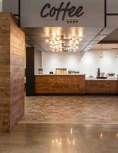 the inside of a coffee shop with wooden counter tops and lights hanging from the ceiling