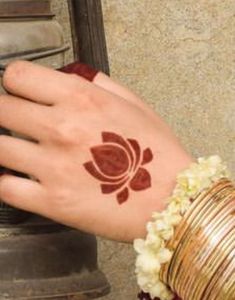 a woman's hand with a henna on it and a bell in the background