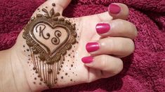 a woman's hand with henna on it and a heart drawn on the palm