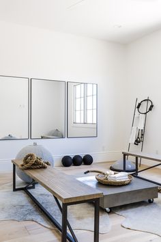 a living room with two mirrors on the wall and a coffee table in front of it