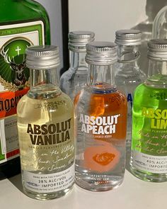 three bottles of absolut vanilla, absolut peach and absolut apricot