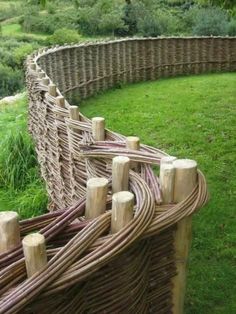 a fence made out of wood sticks in the grass