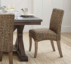 a dining room table with two chairs and a wine bottle on top of the table