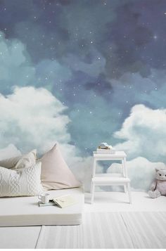 there is a white chair sitting in front of a wall with clouds and stars on it