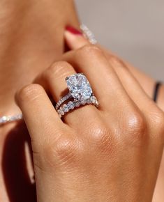 a woman's hand holding a diamond ring