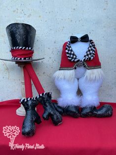 a couple of stuffed animals sitting next to each other on a red cloth covered table