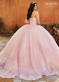 a woman in a pink ball gown standing outside