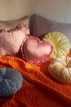 four pillows are arranged on an orange blanket