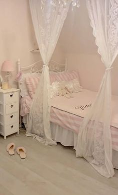 a bedroom with a bed, dresser and white curtains