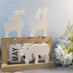 a couple of wooden animals sitting on top of a table next to flowers and vases