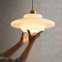 a person reaching up to a light fixture